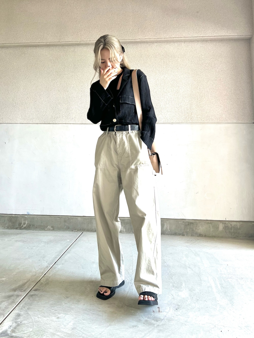 ブラック系のトップス、ベージュ系のその他パンツ、ブラック系のサンダルを着用したレディースの夏コーディネートの2枚目の写真