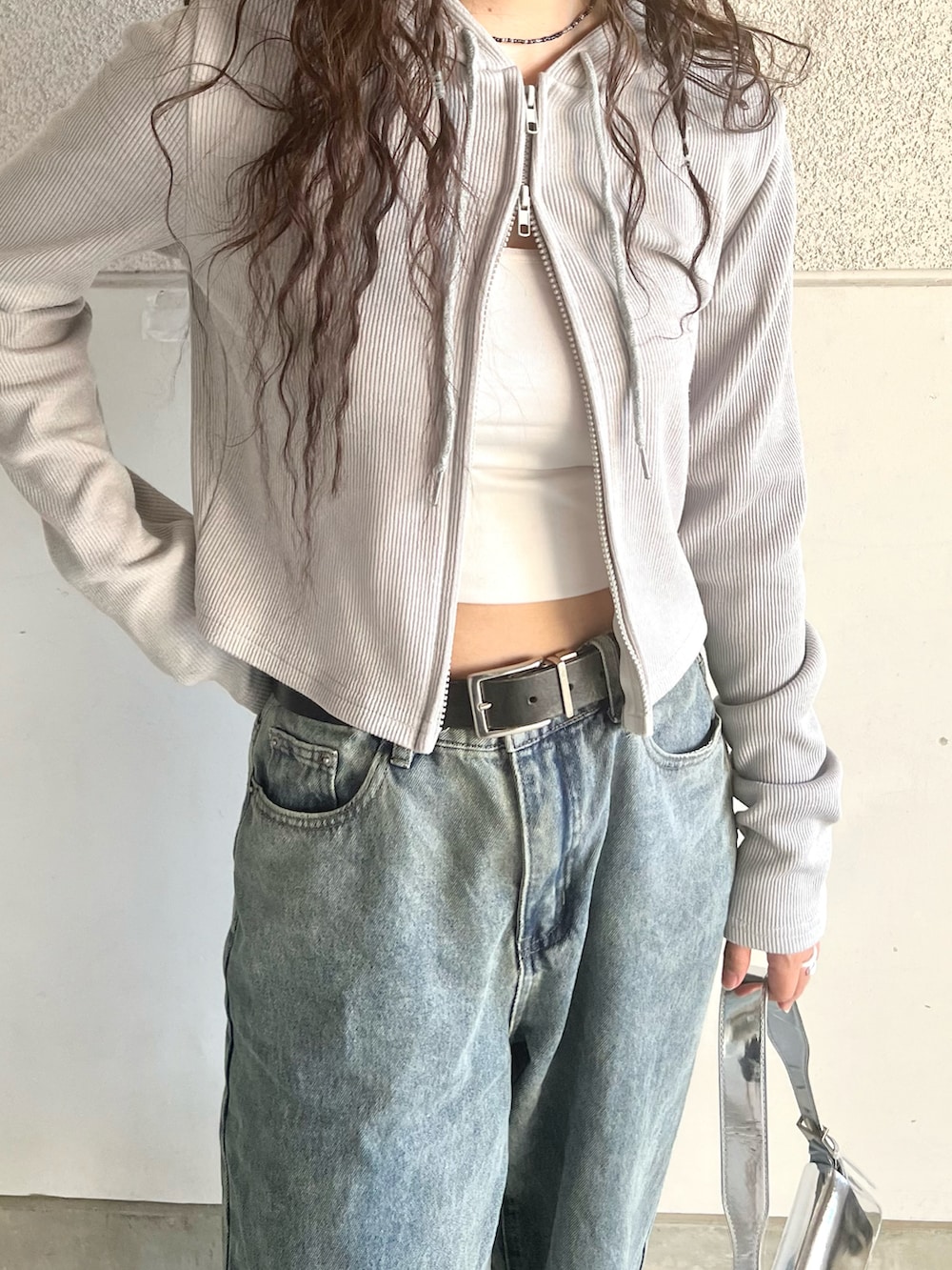 グレー系のスニーカー、グレー系のパーカー、ブルー系のデニムパンツを着用したレディースの春コーディネートの2枚目の写真