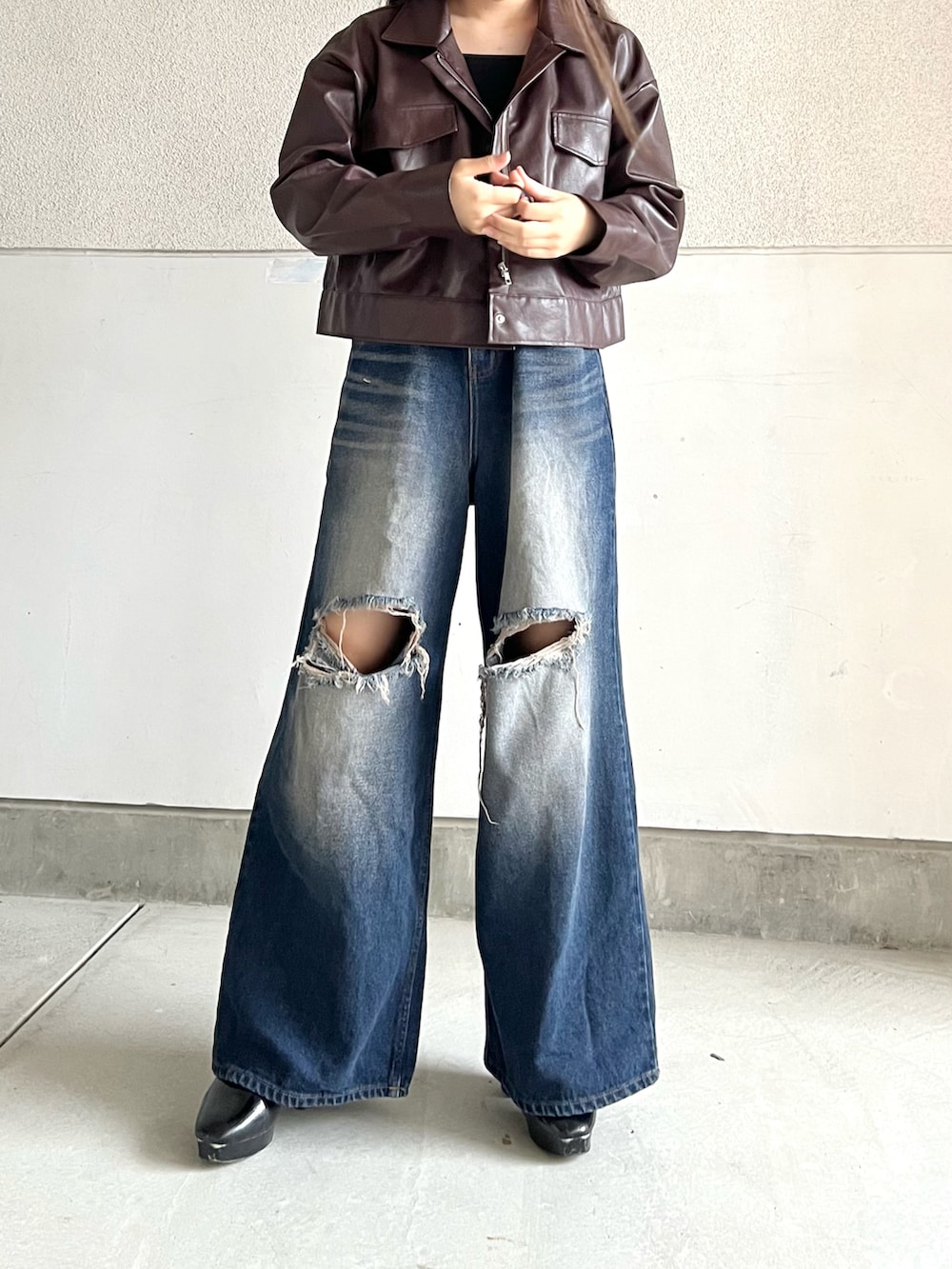 ブラック系のブーツ、ブルー系のデニムパンツ、ブラウン系のジャケット/アウターを着用したレディースの秋コーディネートの2枚目の写真