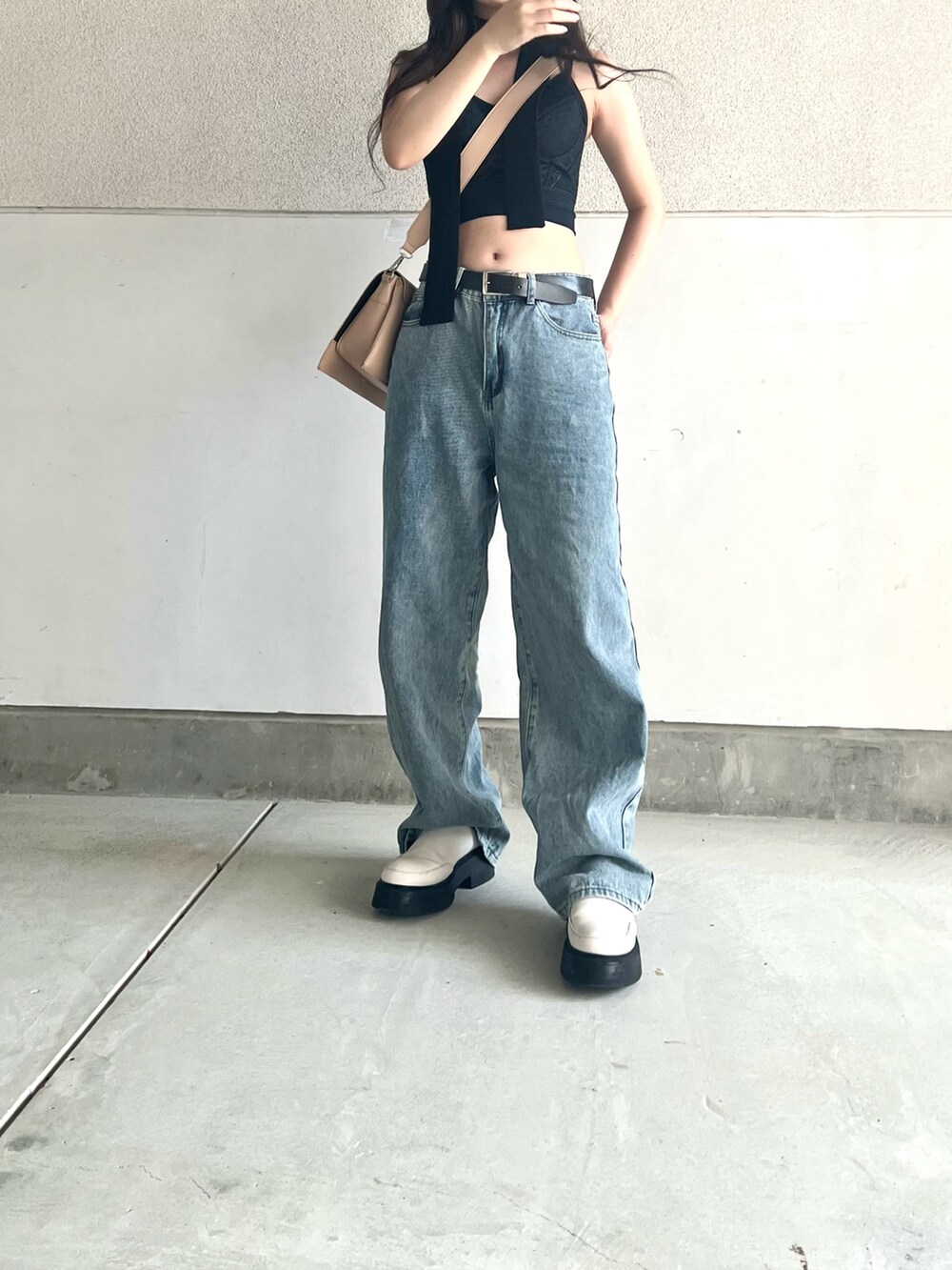 ブルー系のデニムパンツ、ベージュ系のショルダーバッグ、ホワイト系のシューズを着用したレディースの夏コーディネートの4枚目の写真