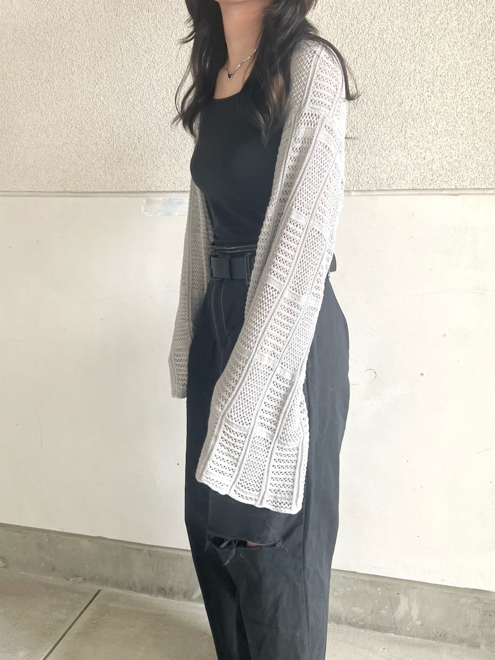 イエロー系のスニーカー、ブラック系のパンツ、グレー系のニット/セーターを着用したレディースの秋コーディネートの2枚目の写真