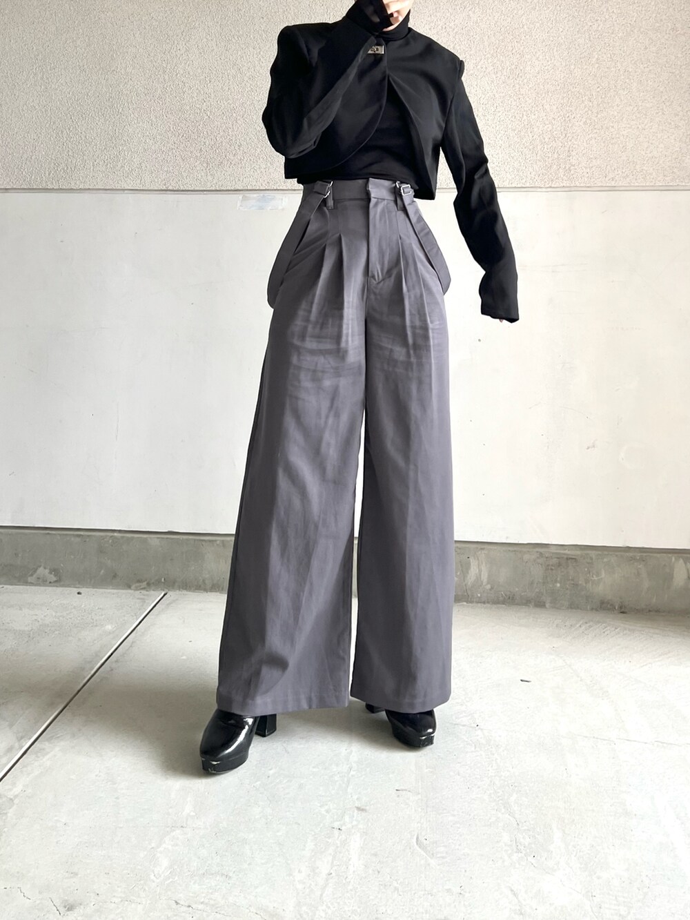 ブラック系のTシャツ/カットソー、ブラック系のノーカラージャケット、グレー系のパンツを着用したレディースの冬コーディネートの4枚目の写真