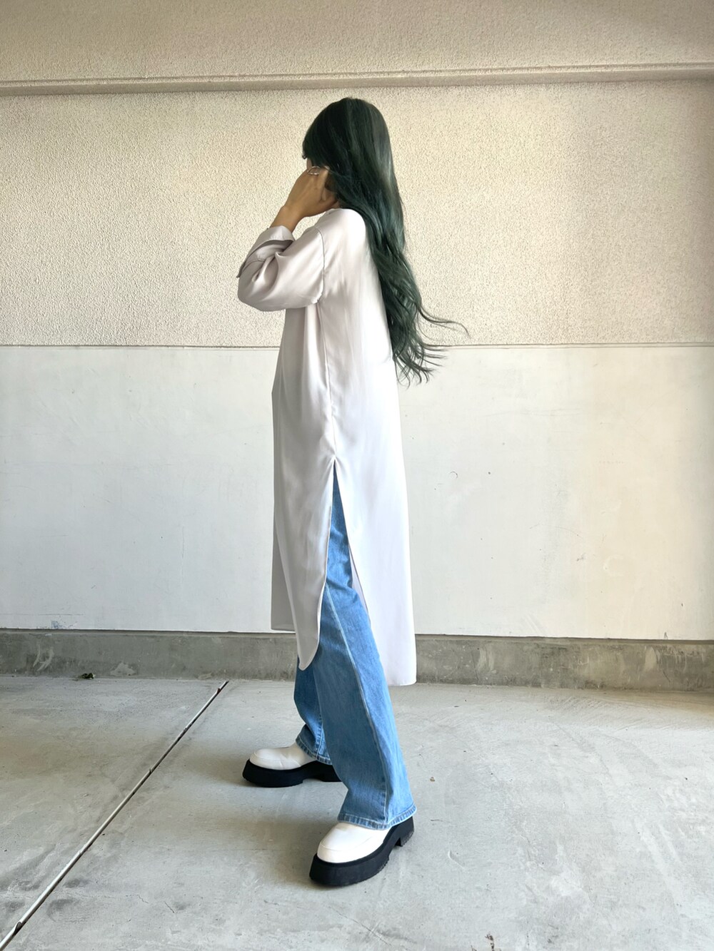 ブルー系のパンツ、ベージュ系のワンピース、ホワイト系のシューズを着用したレディースの秋コーディネートの4枚目の写真