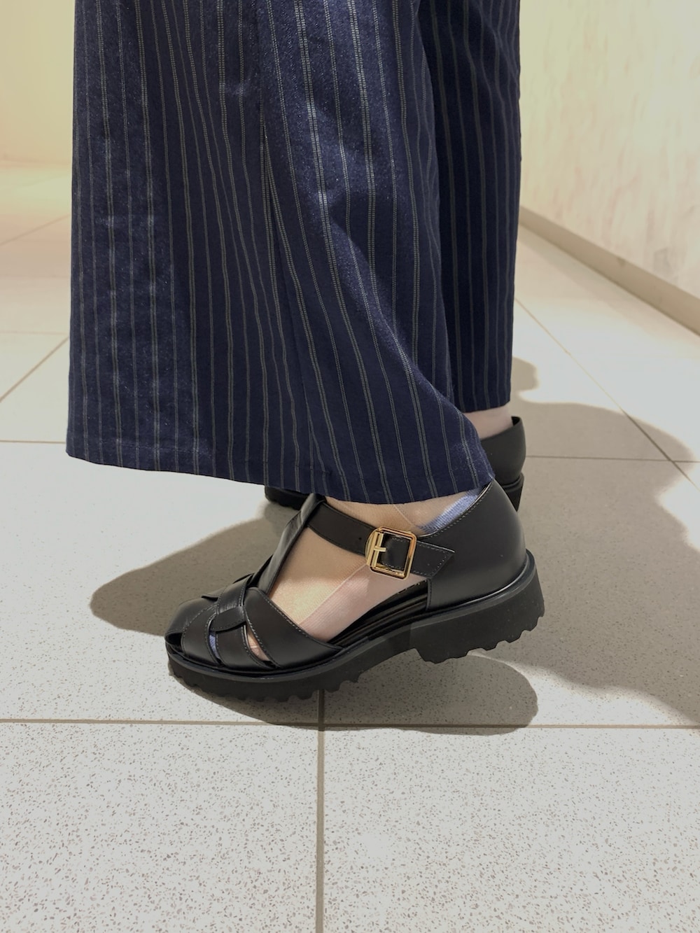 ブラック系のパンプス、ブルー系のパンツ、ホワイト系のTシャツ/カットソーを着用したレディースの夏コーディネートの3枚目の写真