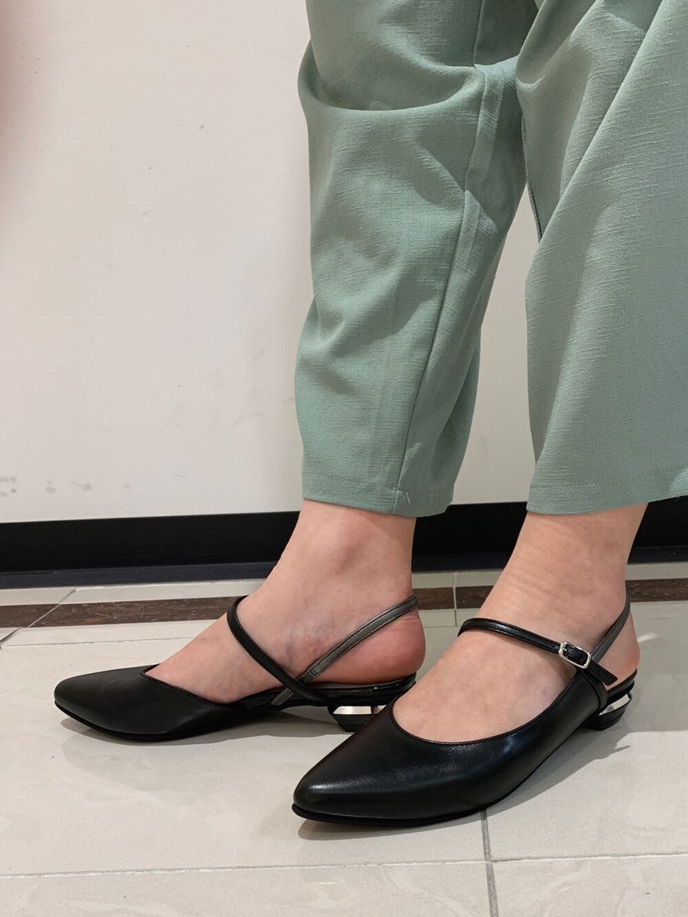 ブラック系のパンプスを着用したレディースの春コーディネートの2枚目の写真