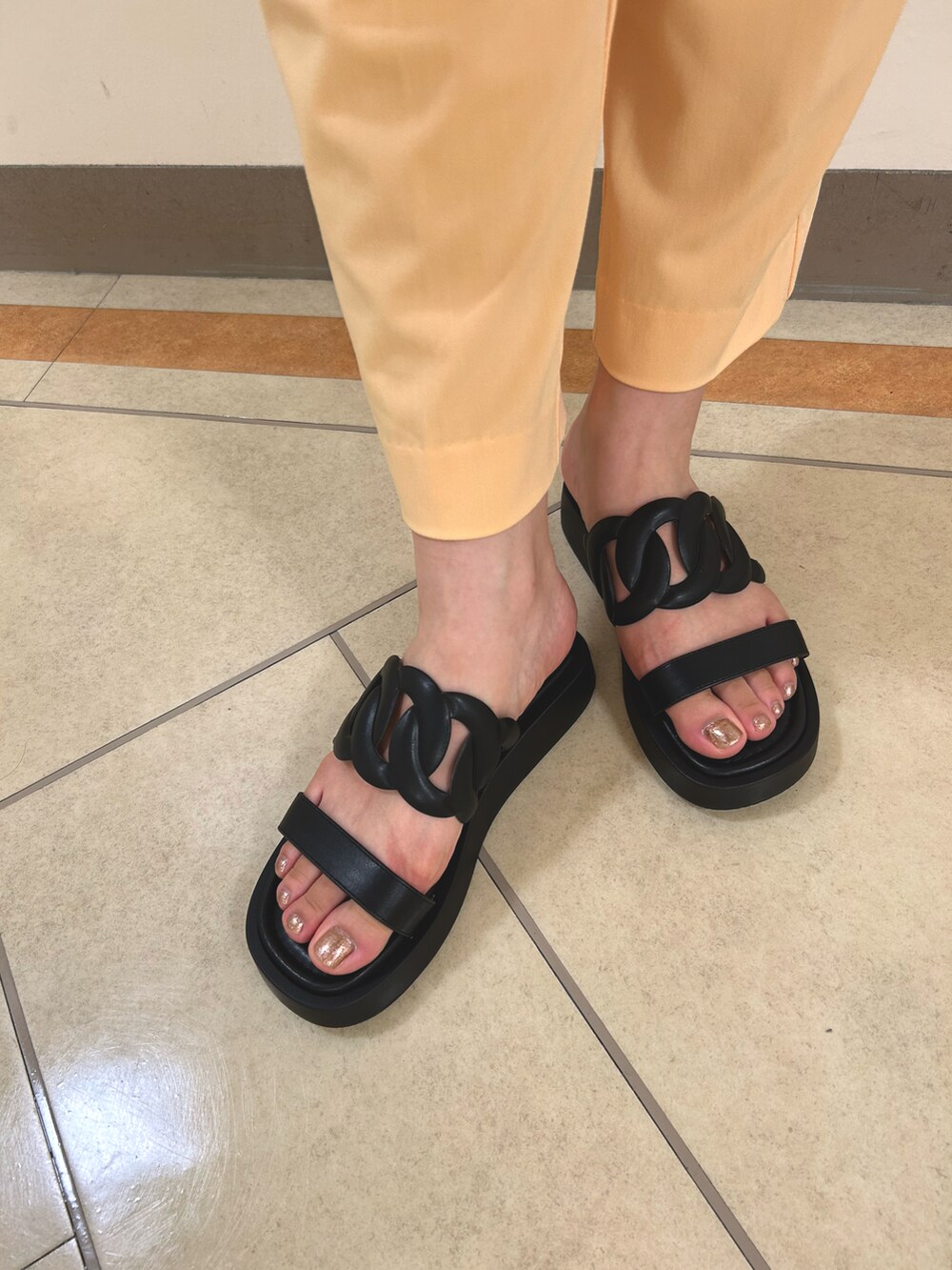 ブラック系のサンダルを着用したレディースの夏コーディネートの2枚目の写真