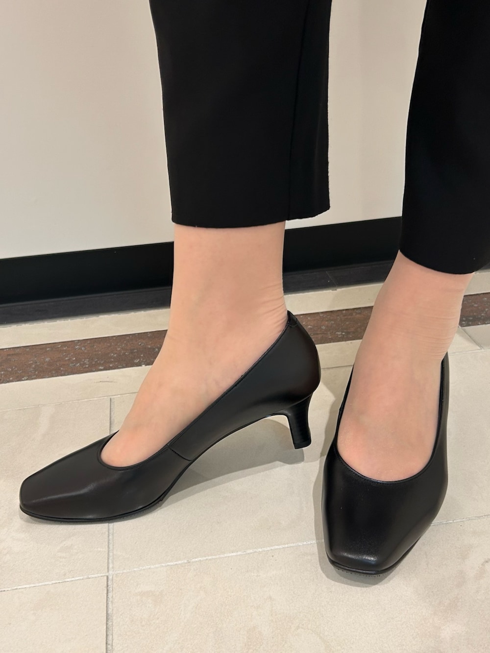 ブラック系のパンプス、ブラック系のショルダーバッグを着用したレディースの春コーディネートの3枚目の写真