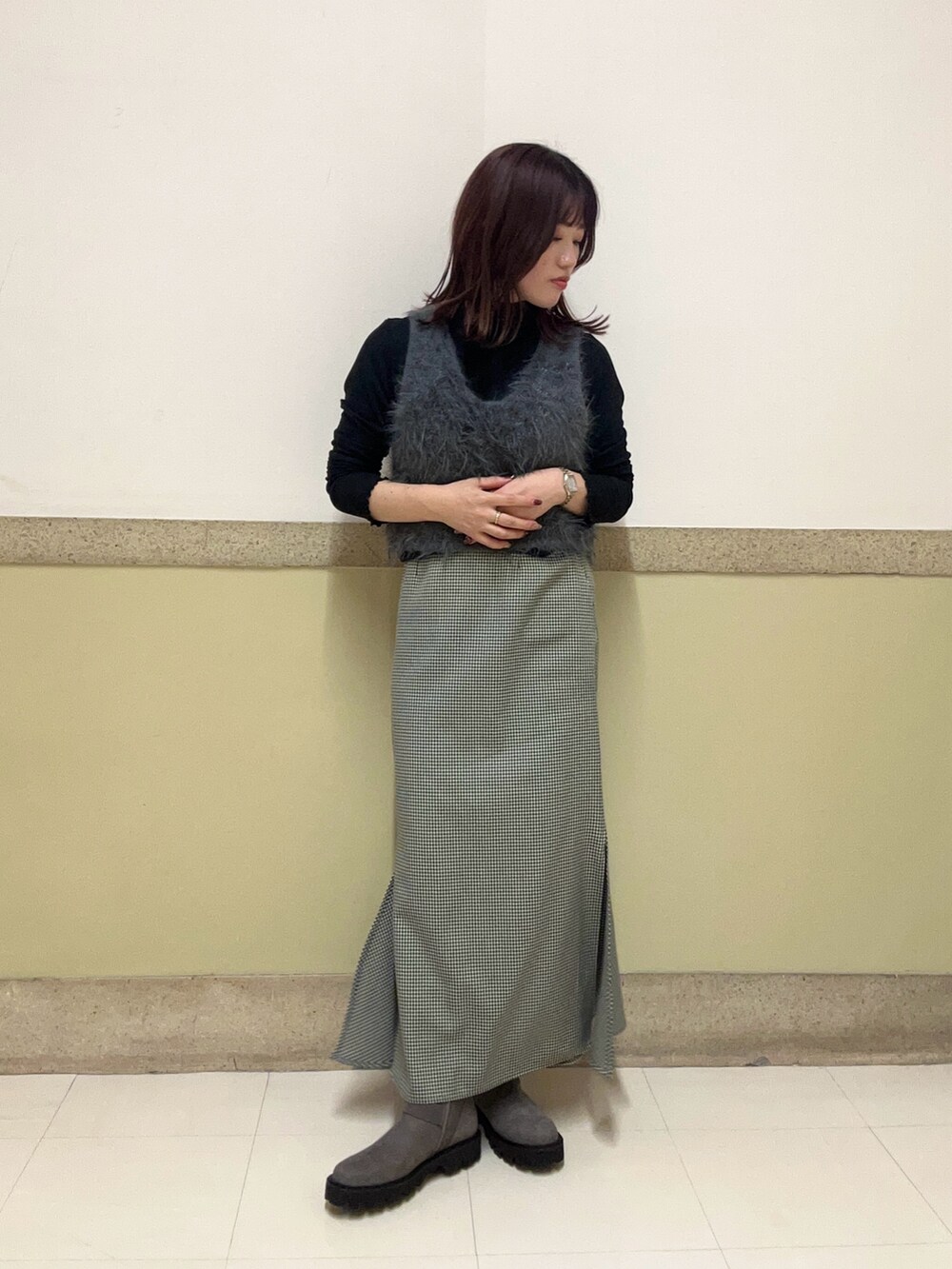 グレー系のブーツを着用したレディースの秋コーディネートの2枚目の写真