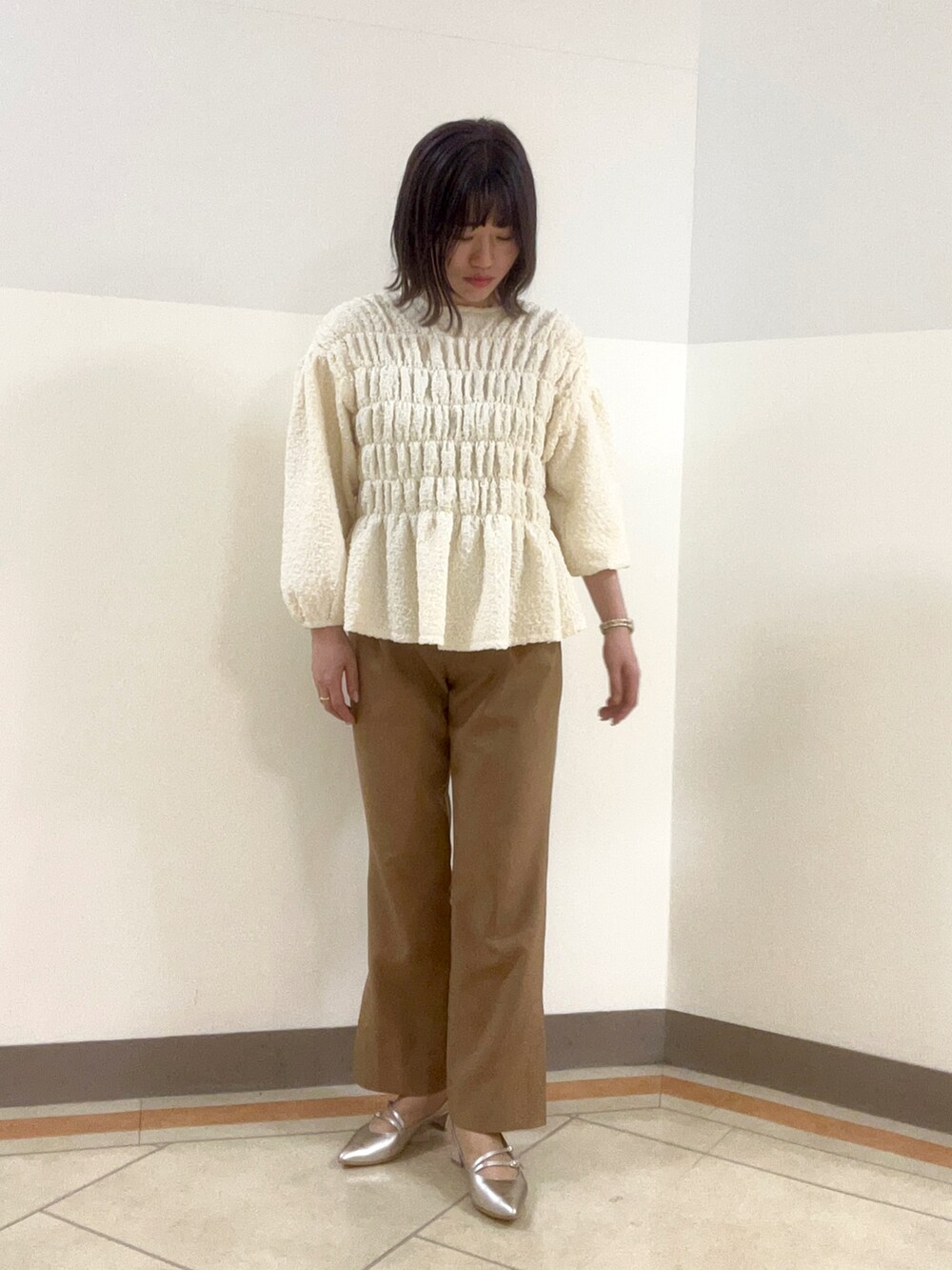 シルバー系のパンプスを着用したレディースの春コーディネートの2枚目の写真