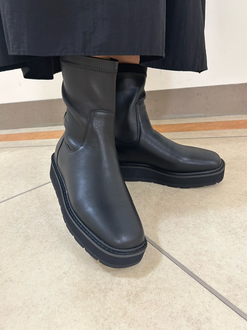 ブラック系のブーツを着用したレディースの秋コーディネートの3枚目の写真