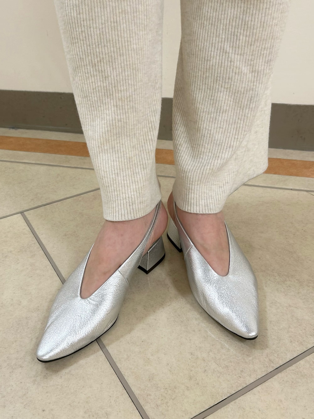 シルバー系のパンプスを着用したレディースの春コーディネートの2枚目の写真