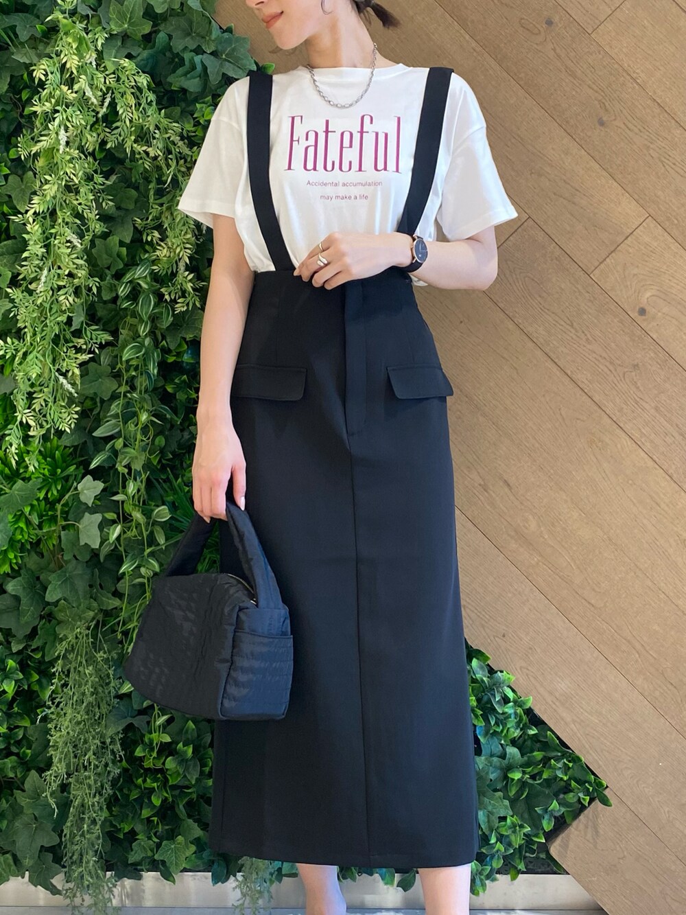ホワイト系のTシャツ/カットソー、ブラック系のスカート、ブラック系のトートバッグを着用したレディースの夏コーディネートの2枚目の写真
