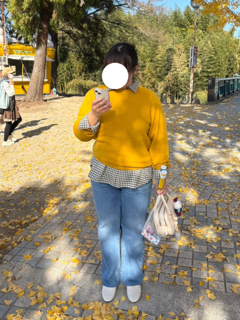 イエロー系のニット/セーター、その他のシャツ/ブラウス、ブルー系のデニムパンツを着用したレディースの冬コーディネートの2枚目の写真