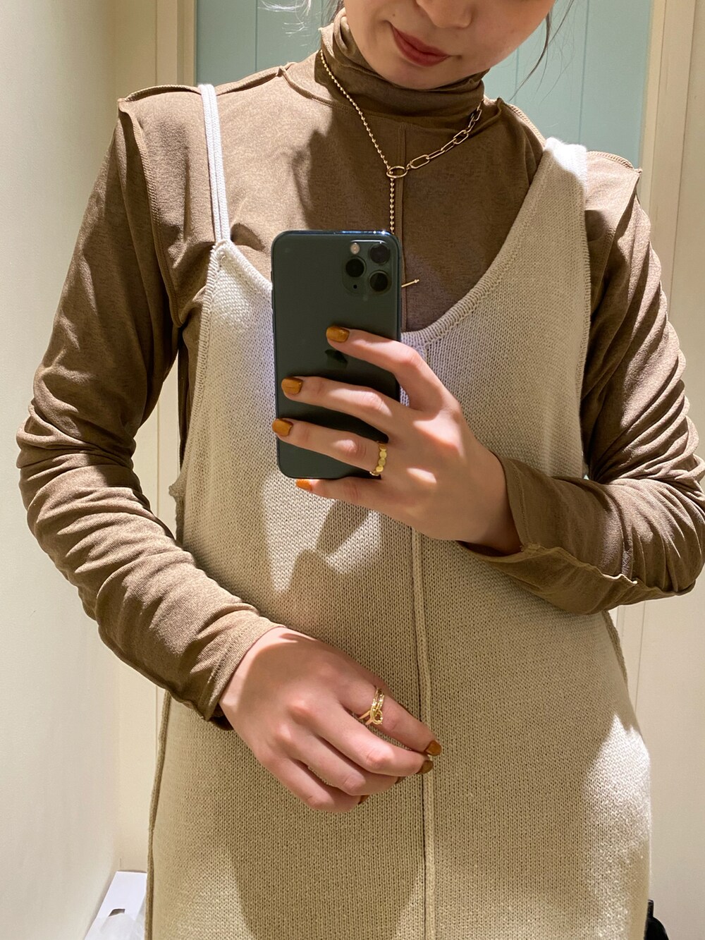 ホワイト系のワンピース、ブラウン系のブーツを着用したレディースの冬コーディネートの5枚目の写真