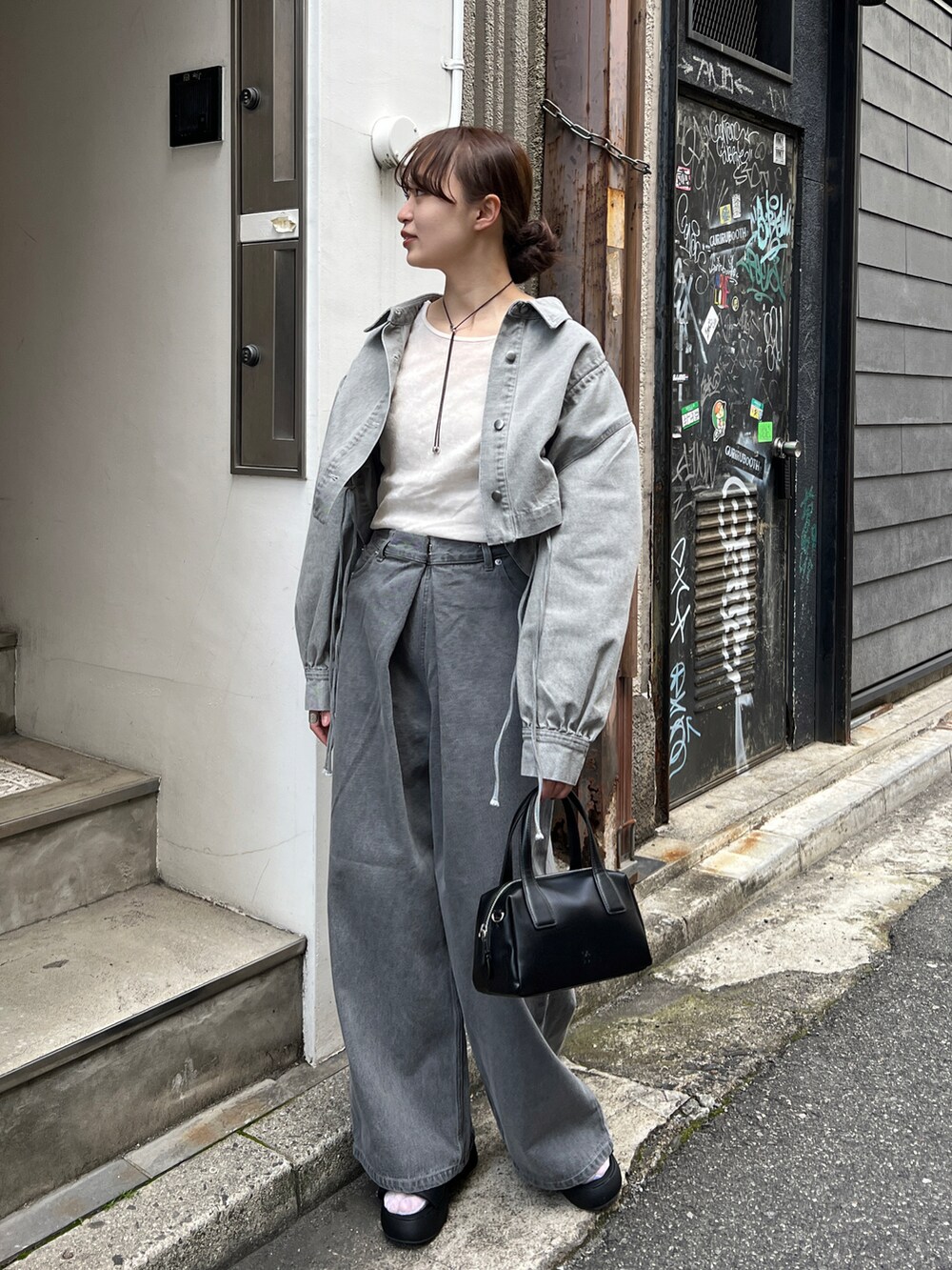 グレー系のデニムパンツ、ホワイト系のTシャツ/カットソー、グレー系のデニムジャケットを着用したレディースの春コーディネートの2枚目の写真