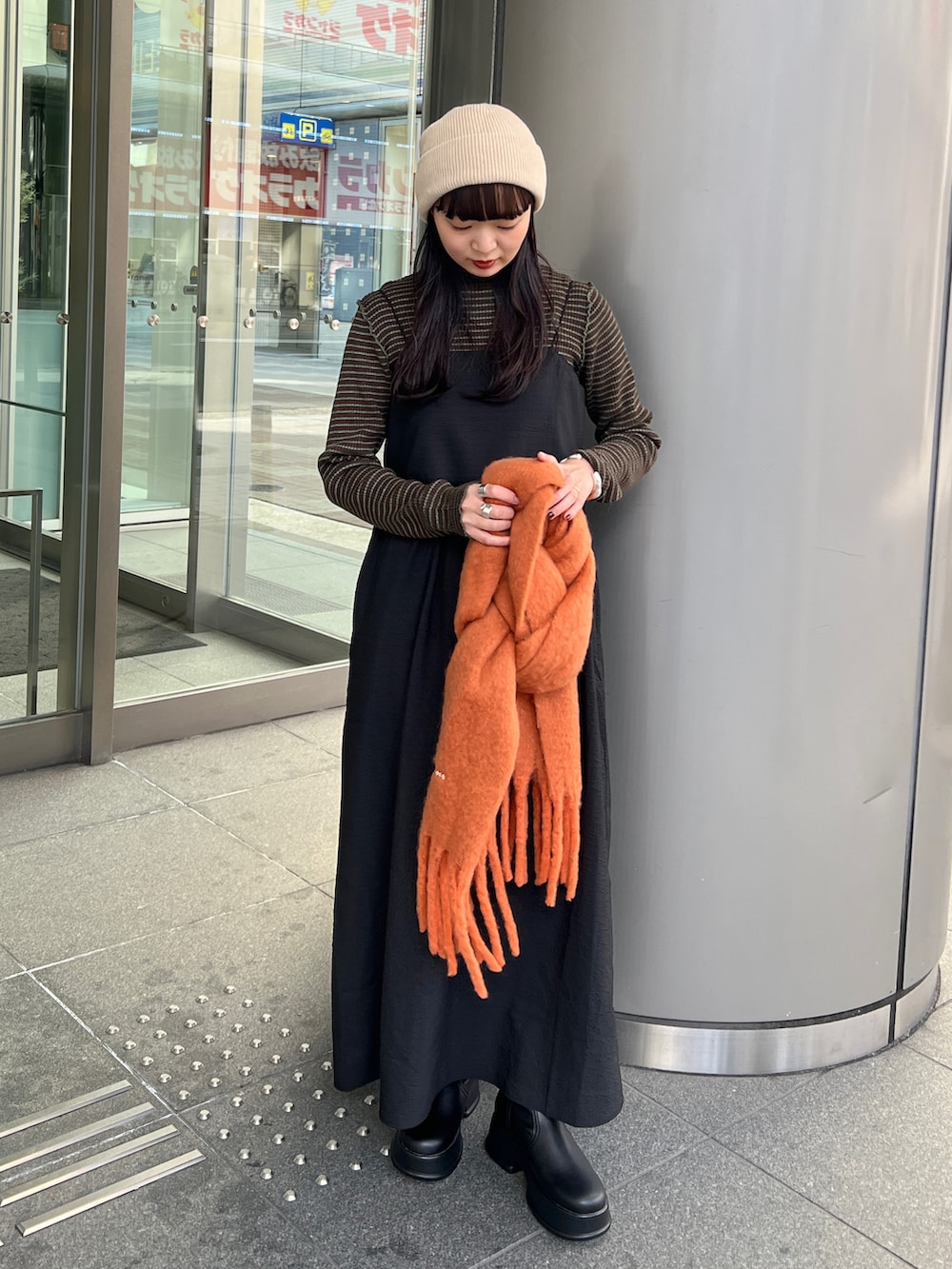 ブラック系のブーツ、ブラック系のワンピース、ブラウン系のニット/セーターを着用したレディースの冬コーディネートの3枚目の写真