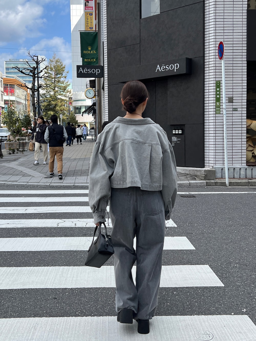 グレー系のデニムパンツ、ホワイト系のTシャツ/カットソー、グレー系のデニムジャケットを着用したレディースの春コーディネートの4枚目の写真