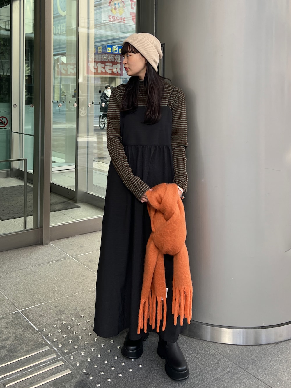 ブラック系のブーツ、ブラック系のワンピース、ブラウン系のニット/セーターを着用したレディースの冬コーディネートの4枚目の写真