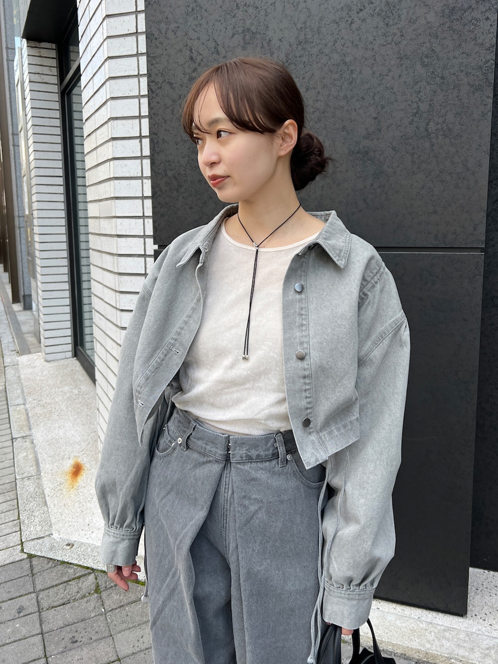 グレー系のデニムパンツ、ホワイト系のTシャツ/カットソー、グレー系のデニムジャケットを着用したレディースの春コーディネートの3枚目の写真