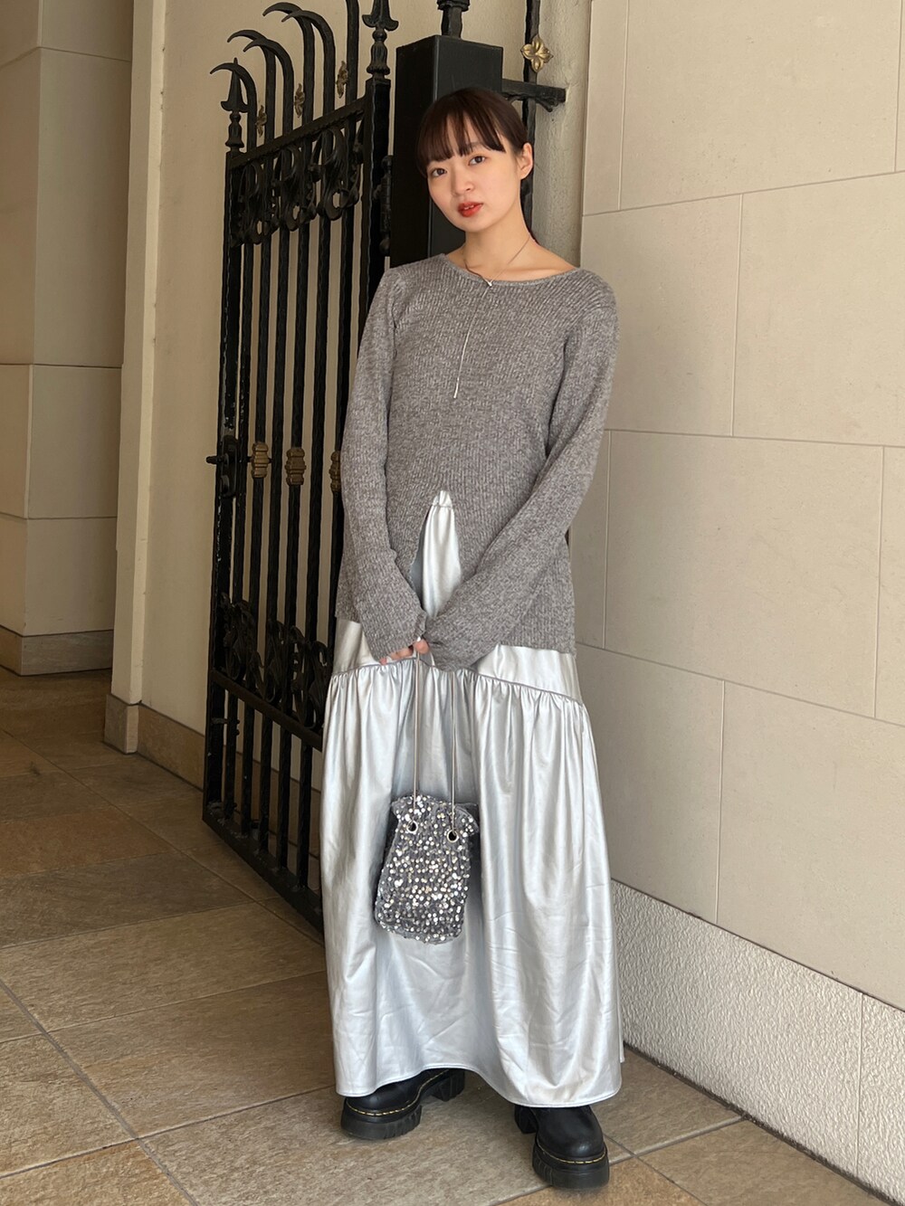 ブラック系のブーツ、シルバー系のスカート、グレー系のTシャツ/カットソーを着用したレディースの冬コーディネートの2枚目の写真