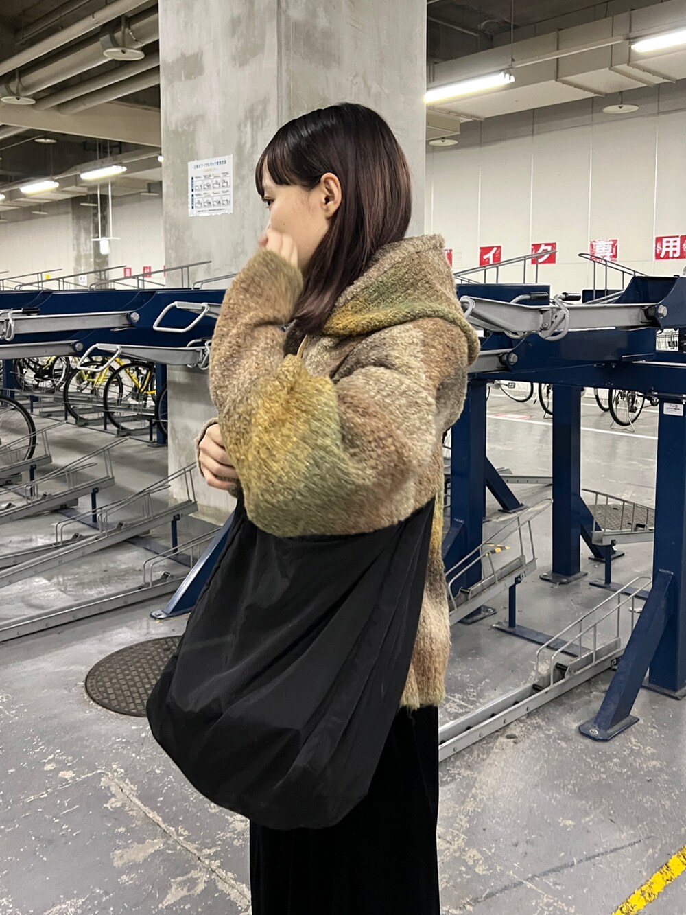 ブラウン系のニット/セーター、ブラック系のワンピース、ブラック系のブーツを着用したレディースの秋コーディネートの2枚目の写真