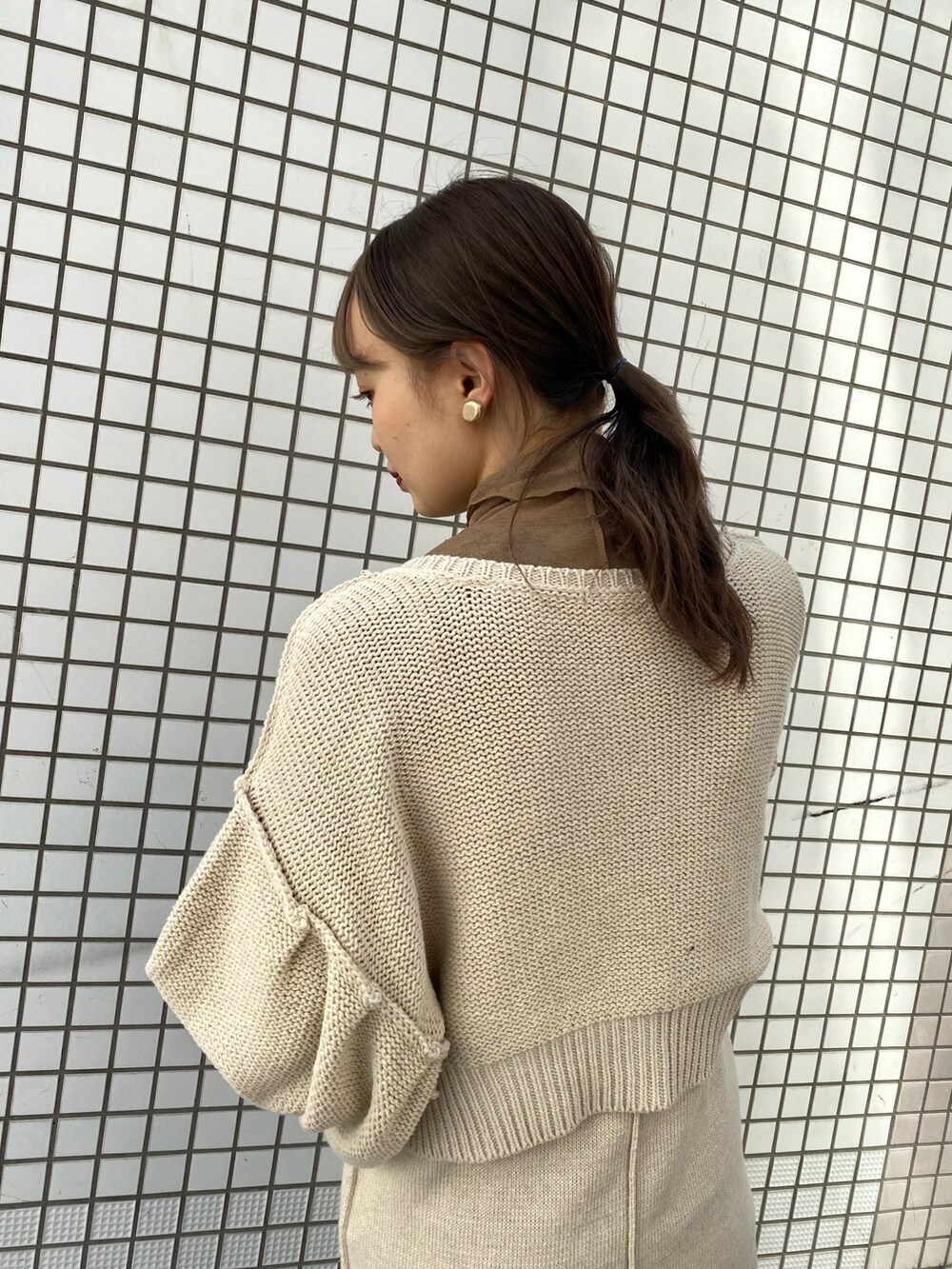 ホワイト系のワンピース、ブラウン系のブーツを着用したレディースの冬コーディネートの3枚目の写真