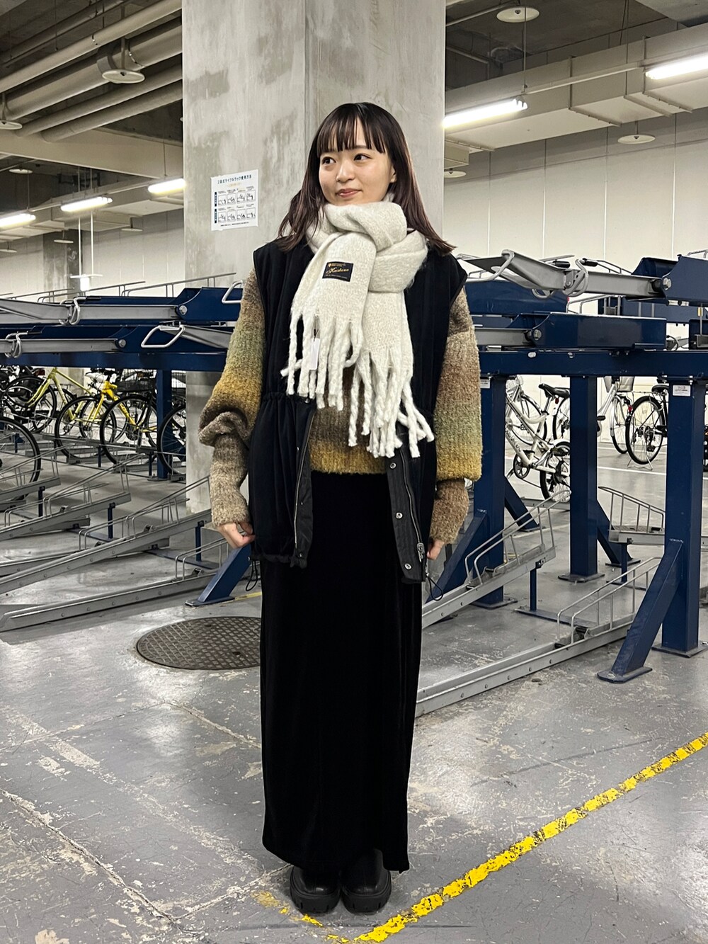 ブラウン系のニット/セーター、ブラック系のワンピース、ブラック系のブーツを着用したレディースの秋コーディネートの4枚目の写真