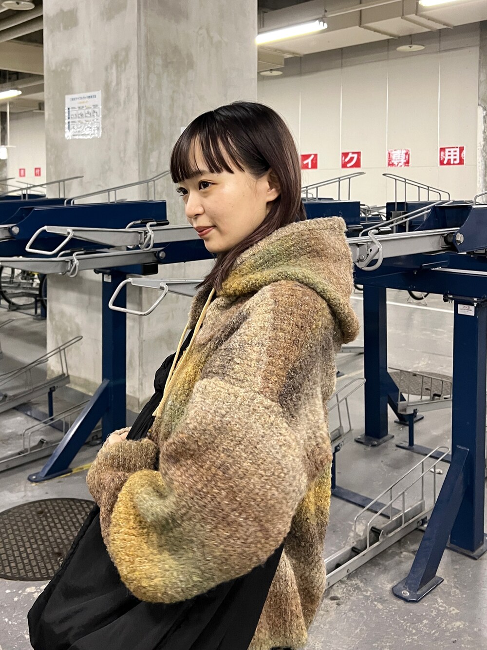 ブラウン系のニット/セーター、ブラック系のワンピース、ブラック系のブーツを着用したレディースの秋コーディネートの3枚目の写真