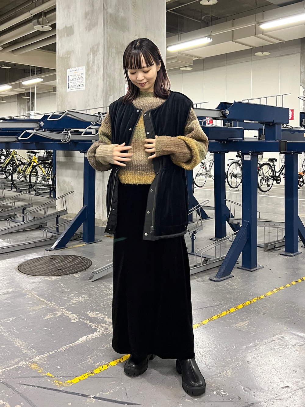 ブラウン系のニット/セーター、ブラック系のワンピース、ブラック系のブーツを着用したレディースの秋コーディネートの5枚目の写真