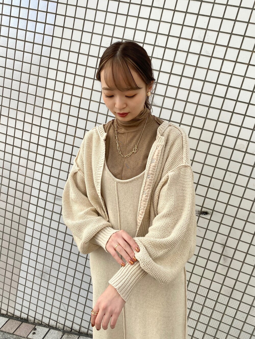 ホワイト系のワンピース、ブラウン系のブーツを着用したレディースの冬コーディネートの2枚目の写真