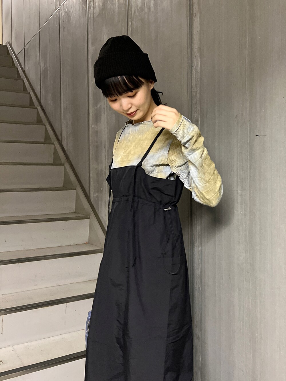 ブラック系のベスト、ブルー系のボストンバッグ、ブラック系のワンピースを着用したレディースの秋コーディネートの5枚目の写真