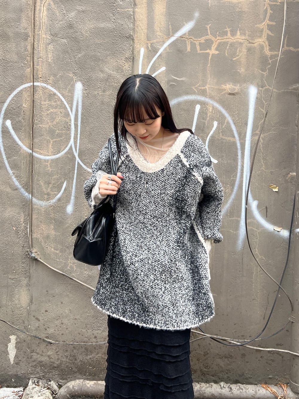 ブラック系のブーツ、ブラック系のスカート、ホワイト系のニット/セーターを着用したレディースの秋コーディネートの4枚目の写真