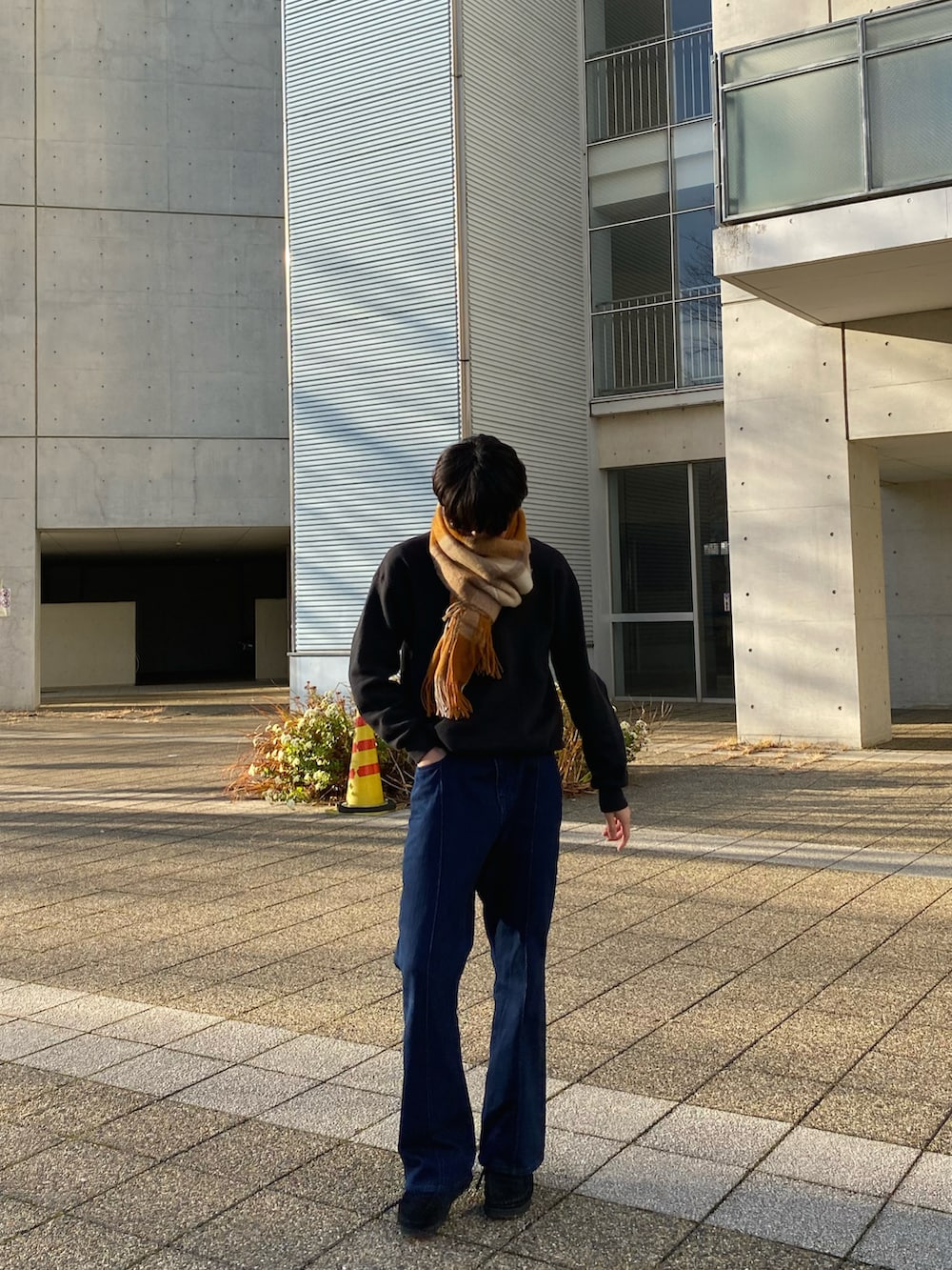 ブラック系のスウェット、ブルー系のパンツ、ブラック系のブーツを着用したメンズの冬コーディネートの2枚目の写真