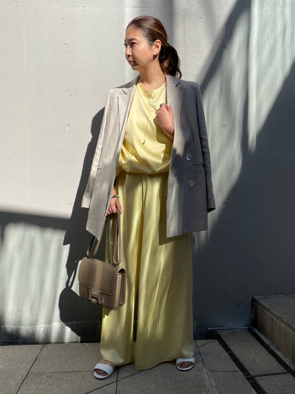 イエロー系のその他パンツ、ベージュ系のテーラードジャケット、イエロー系のTシャツ/カットソーを着用したレディースの冬コーディネートの4枚目の写真