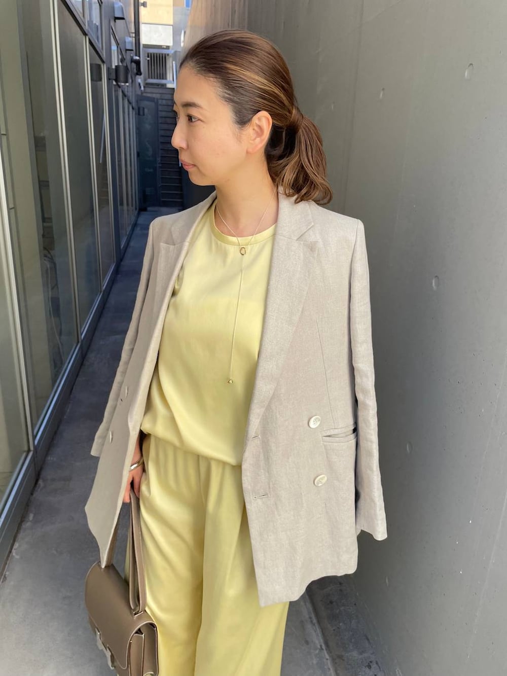 イエロー系のその他パンツ、ベージュ系のテーラードジャケット、イエロー系のTシャツ/カットソーを着用したレディースの冬コーディネートの5枚目の写真