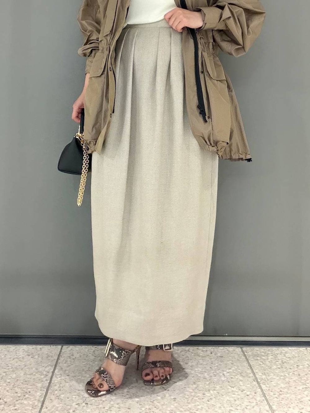 ホワイト系のスカート、ベージュ系のブルゾン、ホワイト系のTシャツ/カットソーを着用したレディースの春コーディネートの4枚目の写真