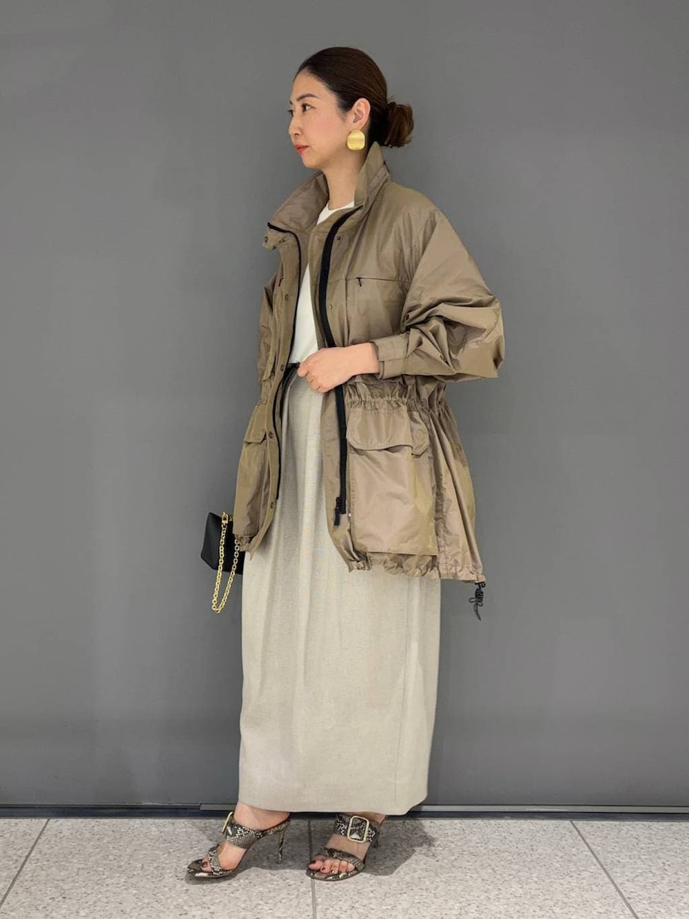 ホワイト系のスカート、ベージュ系のブルゾン、ホワイト系のTシャツ/カットソーを着用したレディースの春コーディネートの2枚目の写真