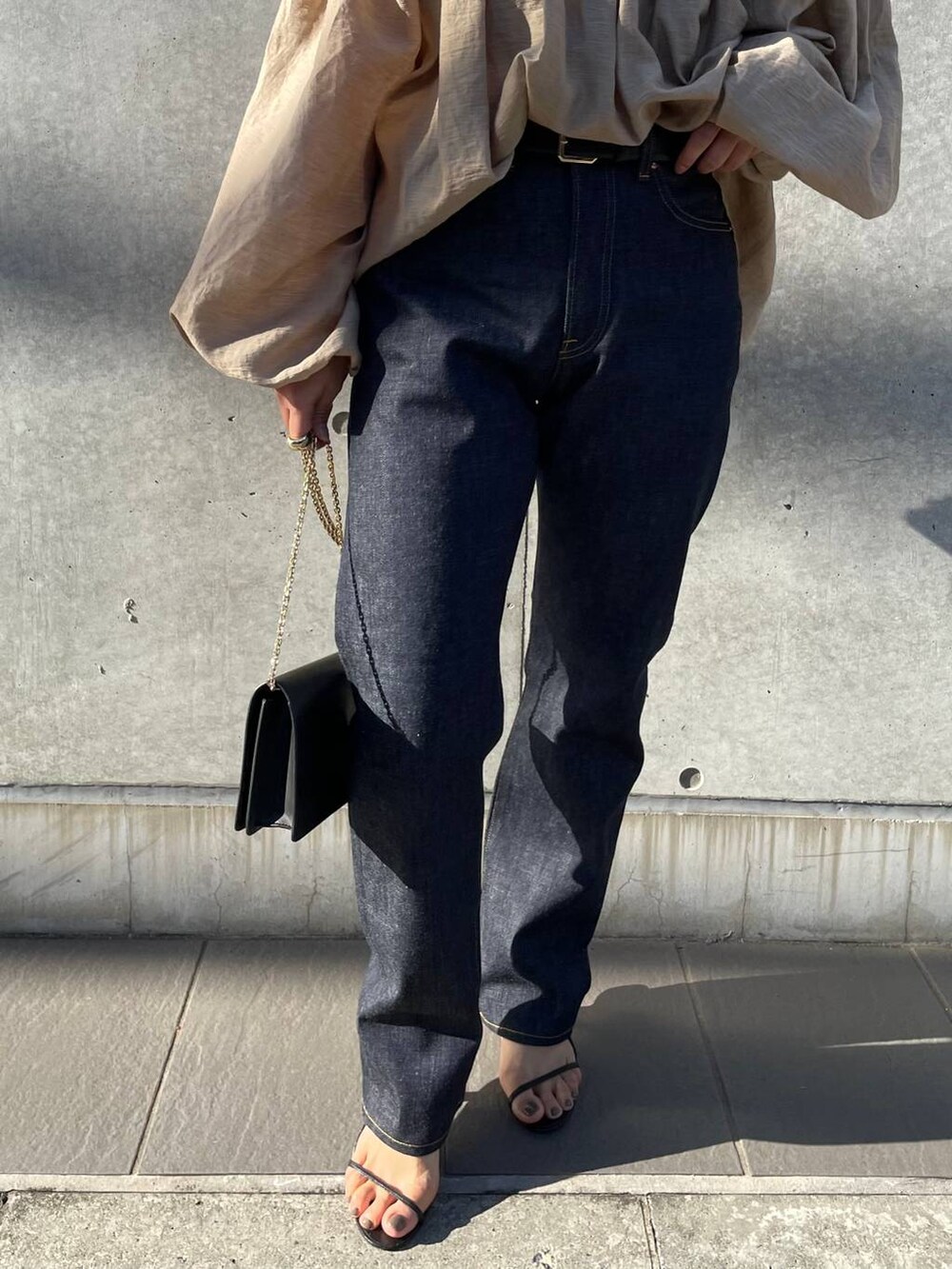 ブラック系のサンダル、ブルー系のデニムパンツ、ベージュ系のシャツ/ブラウスを着用したレディースの冬コーディネートの6枚目の写真