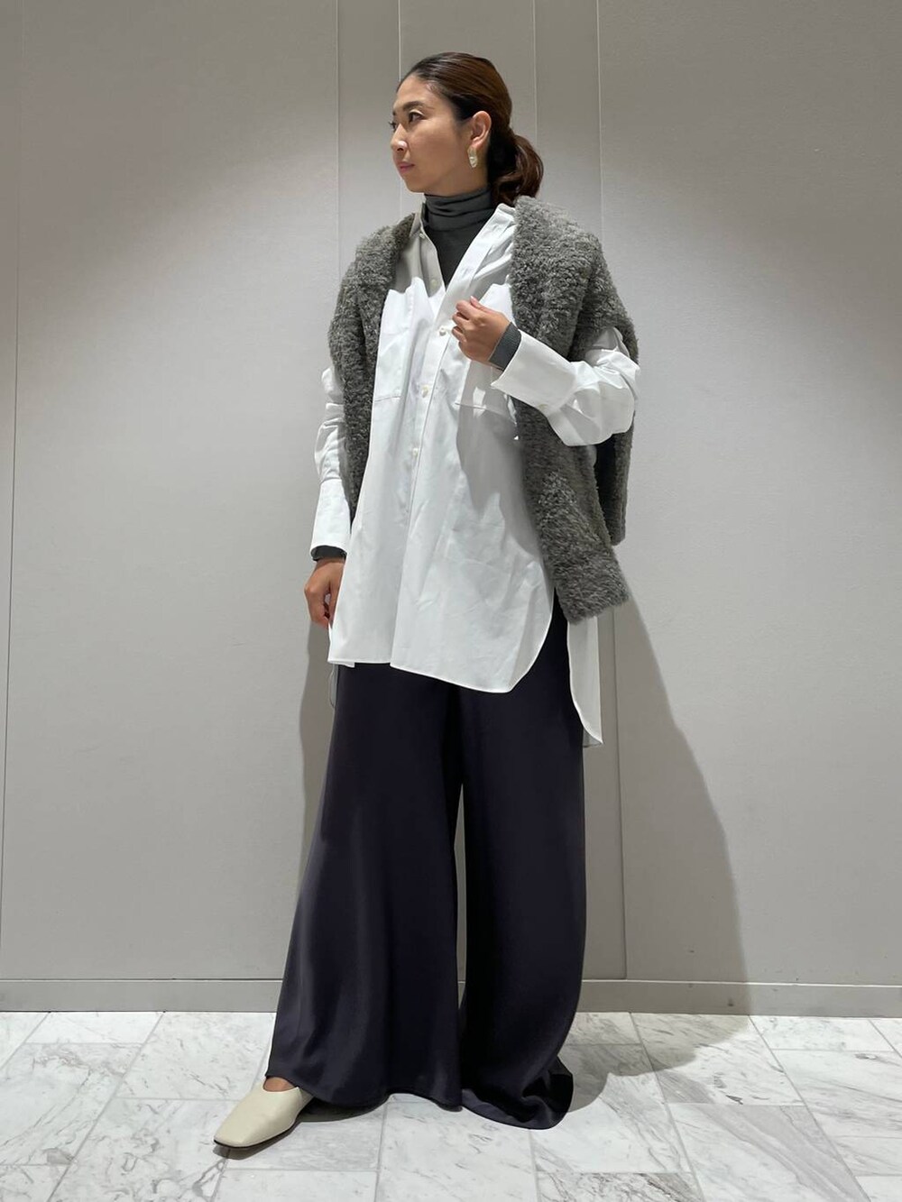 グレー系のカーディガン/ボレロ、ホワイト系のシャツ/ブラウス、グレー系のニット/セーターを着用したレディースの秋コーディネートの5枚目の写真