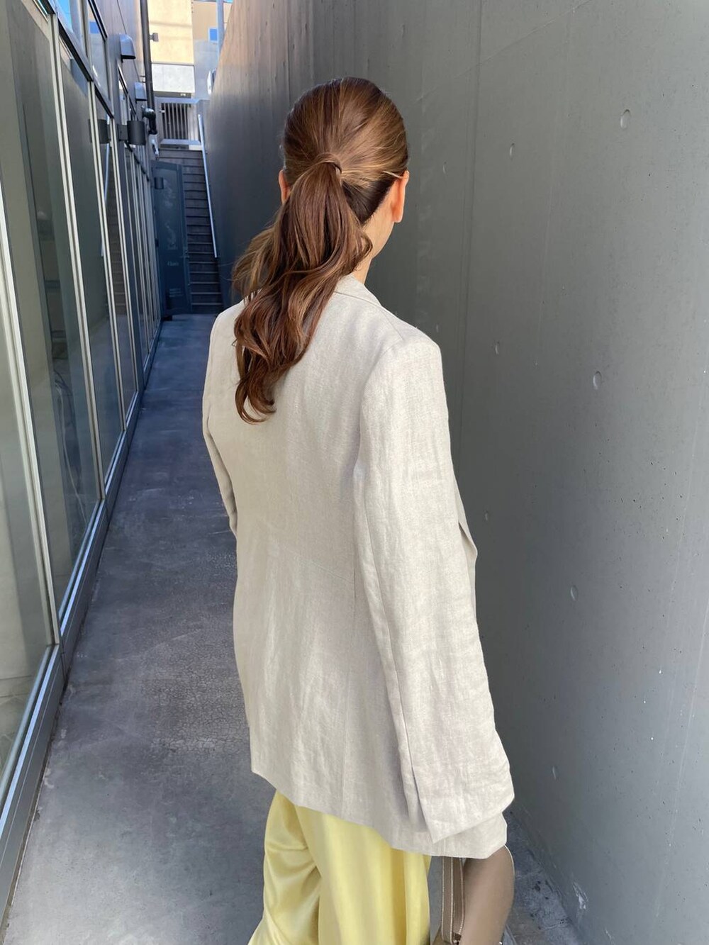 イエロー系のその他パンツ、ベージュ系のテーラードジャケット、イエロー系のTシャツ/カットソーを着用したレディースの冬コーディネートの6枚目の写真