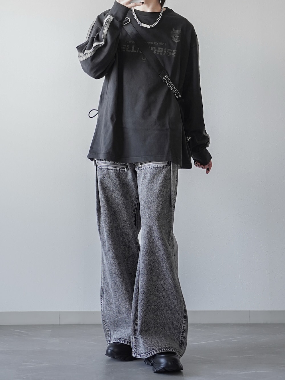 ブラック系のTシャツ/カットソー、ブラック系のショルダーバッグ、グレー系のデニムパンツを着用したメンズの春コーディネートの2枚目の写真