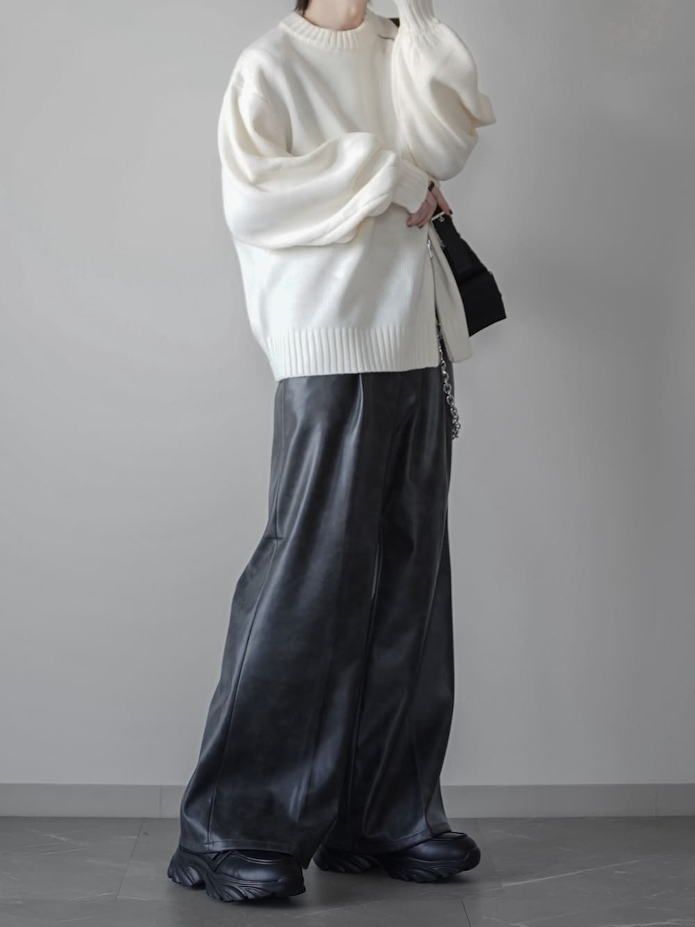 ブラック系のタンクトップ、グレー系のスラックス、ブラック系のローファーを着用したメンズの秋コーディネートの3枚目の写真