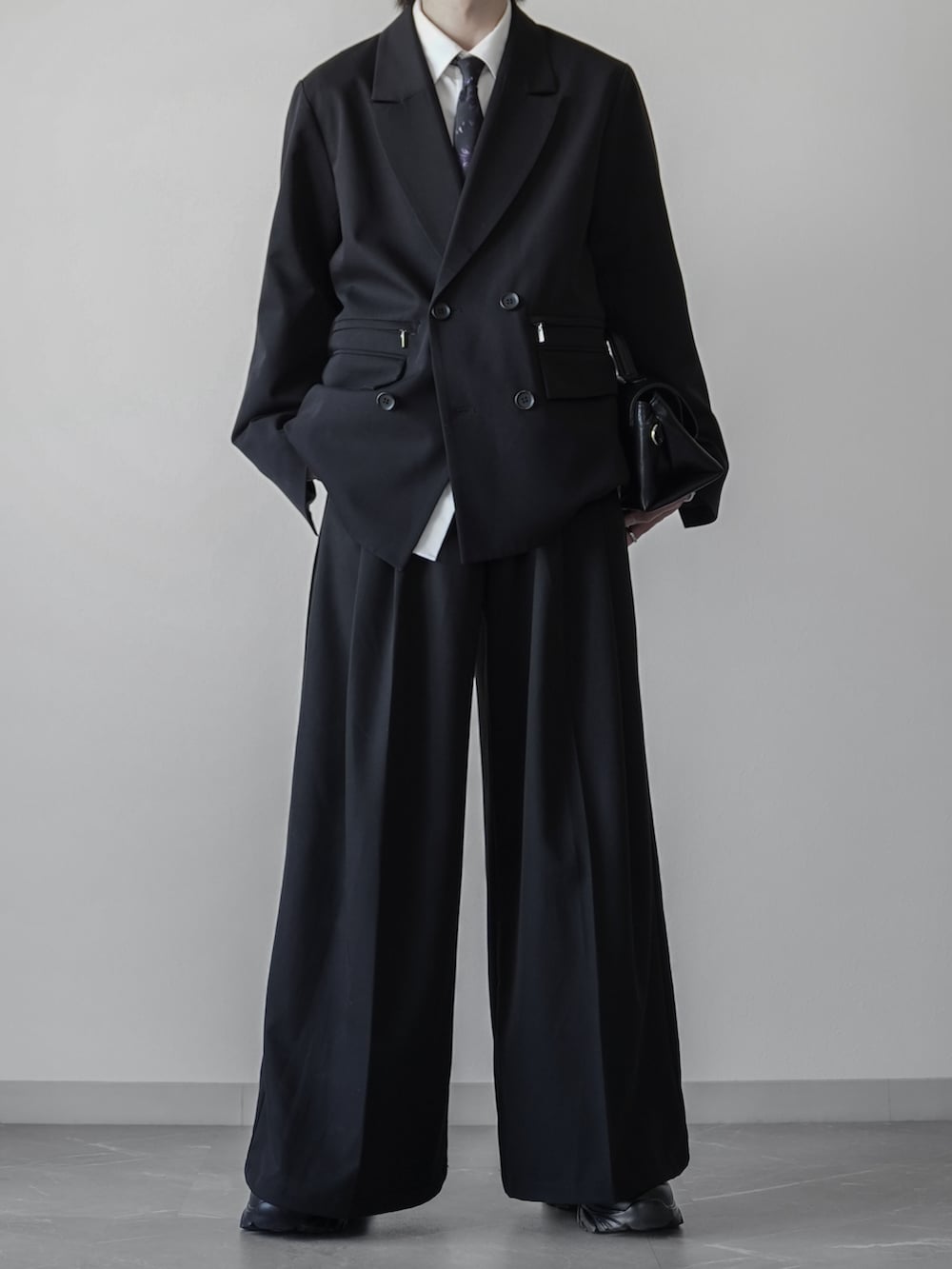 ブラック系のテーラードジャケット、ホワイト系のシャツ/ブラウス、ブラック系のネクタイを着用したメンズの冬コーディネートの2枚目の写真