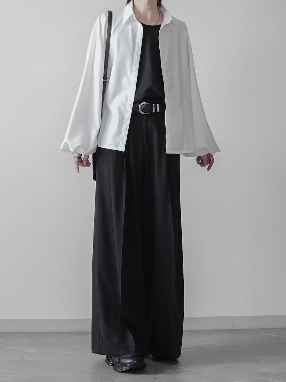 ホワイト系のタンクトップ、ブラック系のショルダーバッグ、ブラック系のスニーカーを着用したメンズの秋コーディネートの3枚目の写真