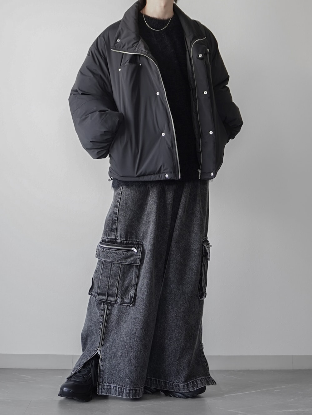 ブラック系のニット/セーター、ブラック系のカーゴパンツ、ブラック系のショルダーバッグを着用したメンズの秋コーディネートの2枚目の写真