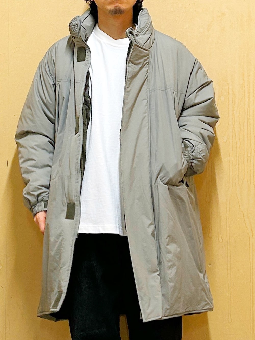 グリーン系のダウンジャケット/コート、ブラック系のデニムパンツを着用したメンズの冬コーディネートの6枚目の写真