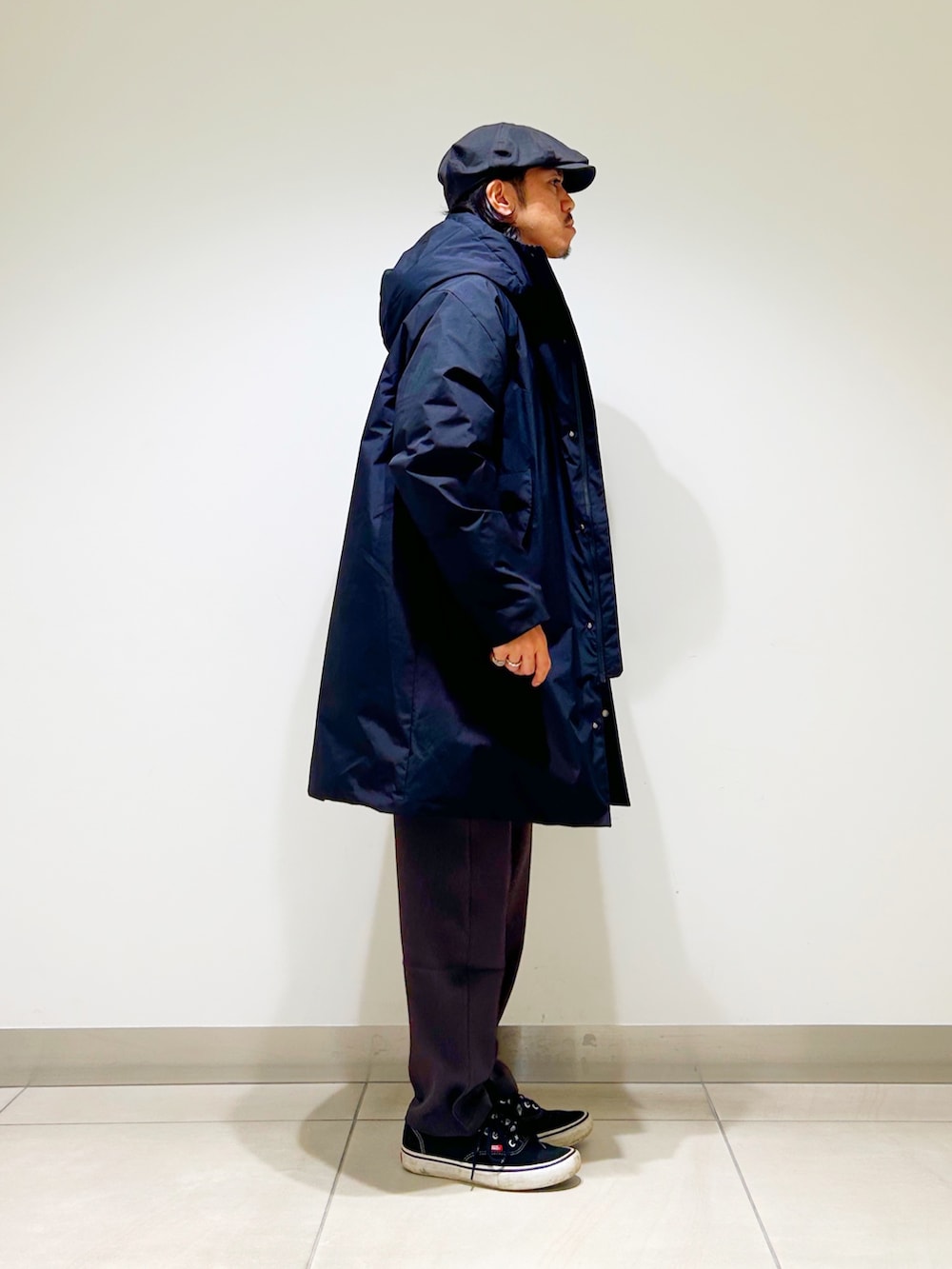 ブラック系のニット/セーター、ブラック系のダウンジャケット/コート、グレー系のスラックスを着用したメンズの秋コーディネートの7枚目の写真