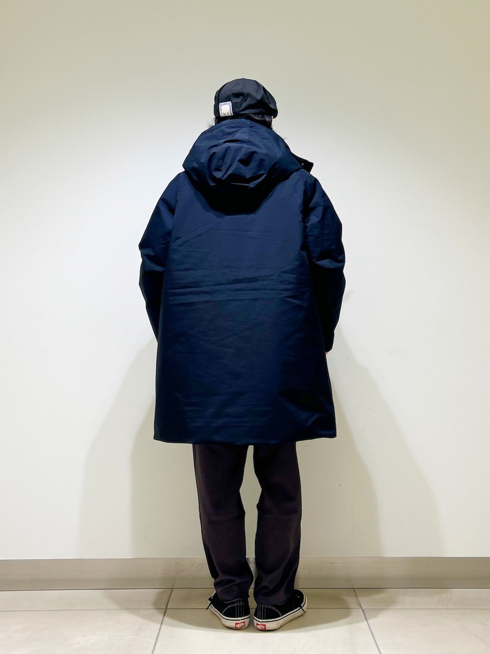 ブラック系のニット/セーター、ブラック系のダウンジャケット/コート、グレー系のスラックスを着用したメンズの秋コーディネートの8枚目の写真