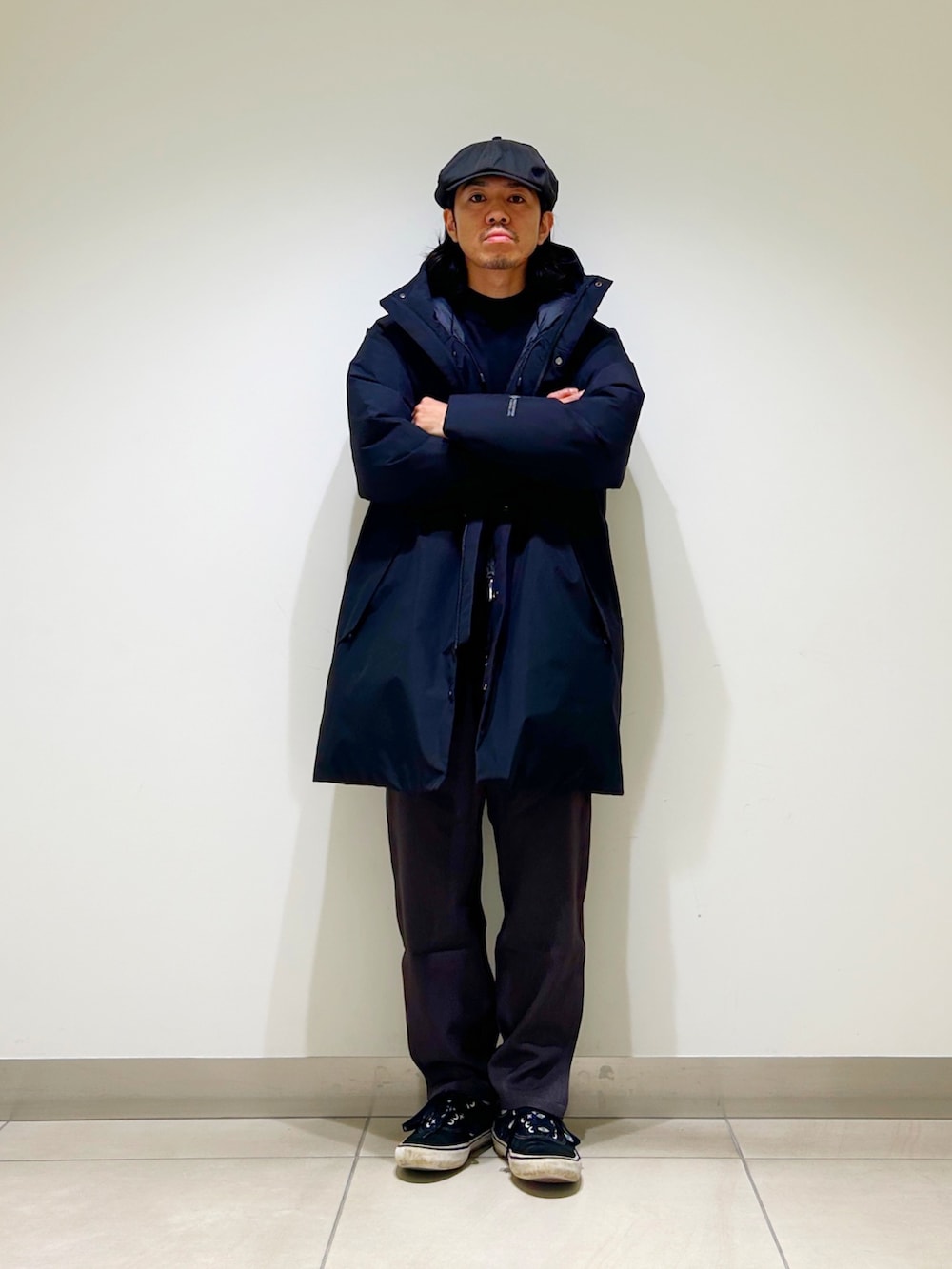 ブラック系のニット/セーター、ブラック系のダウンジャケット/コート、グレー系のスラックスを着用したメンズの秋コーディネートの6枚目の写真