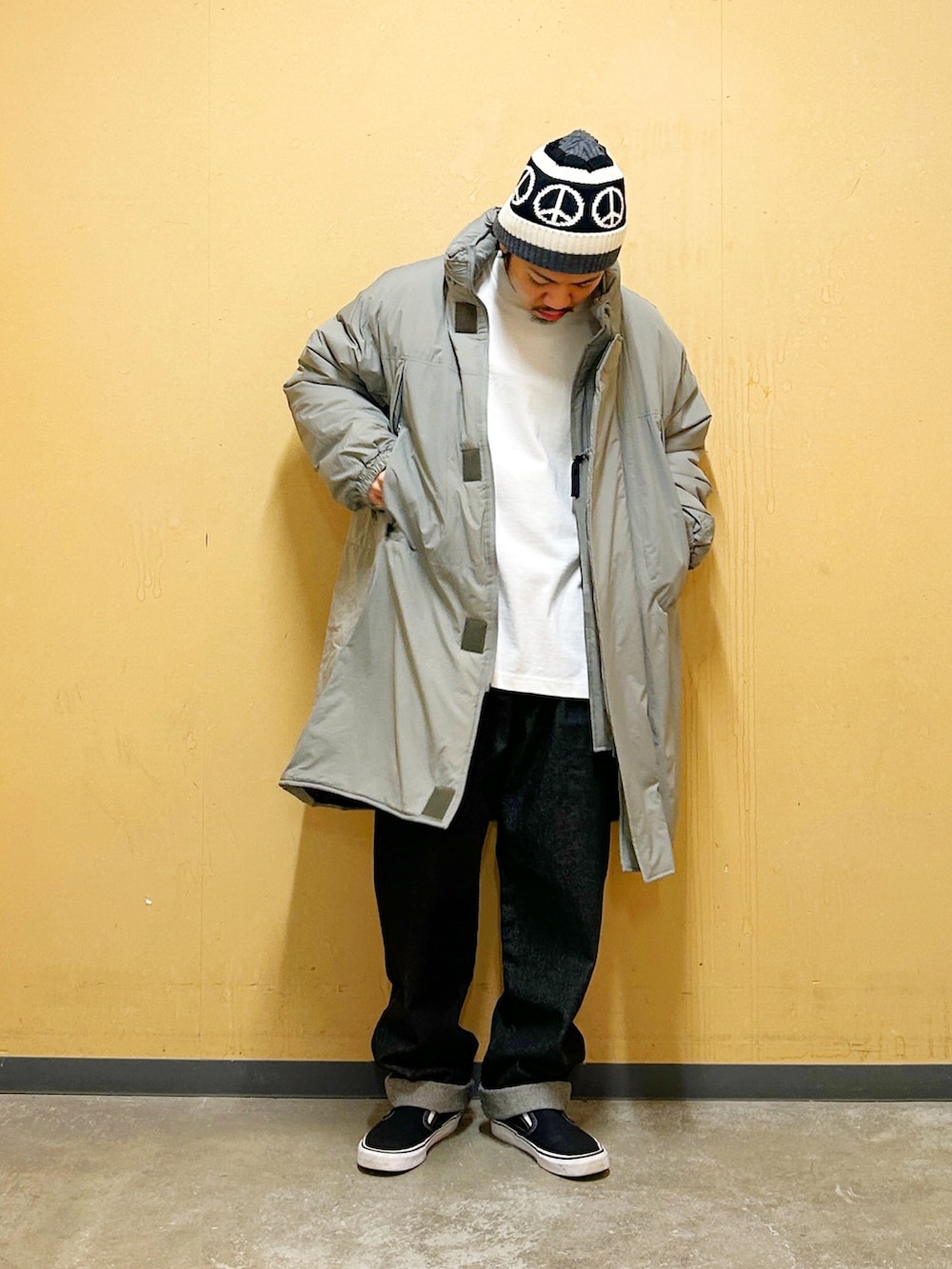 グリーン系のダウンジャケット/コート、ブラック系のデニムパンツを着用したメンズの冬コーディネートの3枚目の写真